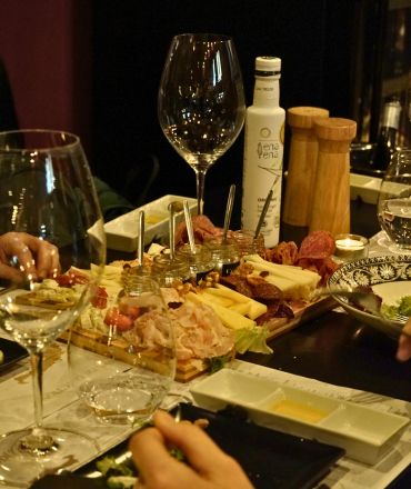 Wine and deli pairing in Athens with cheeses charcuterie and wine glasses at Cinque Wine & Deli